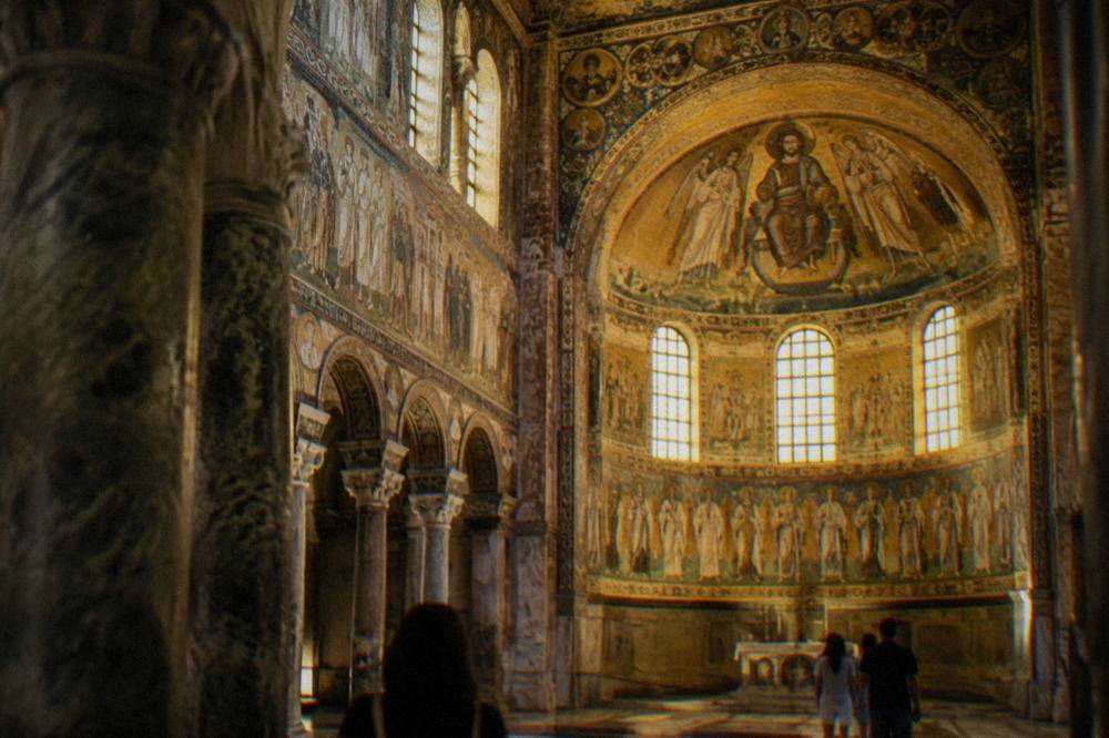 The mosaic-covered interior of a Byzantine church in Ravenna glowing with gold light