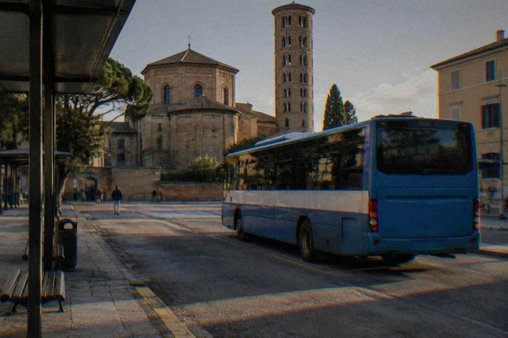 Regional bus parked at a small station terminus in late afternoon light