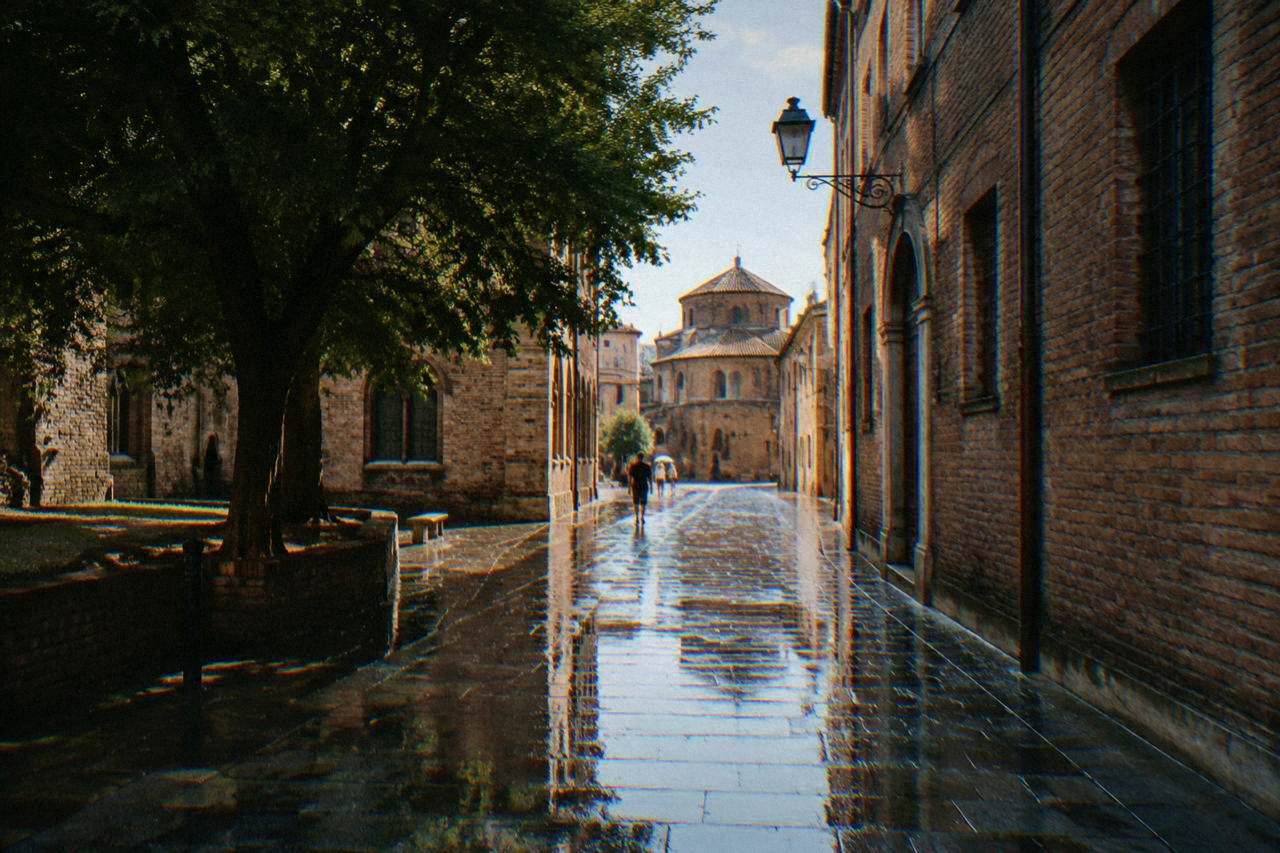 A wet stone street in Ravenna with rain reflections on the paving and old brick buildings on both sides