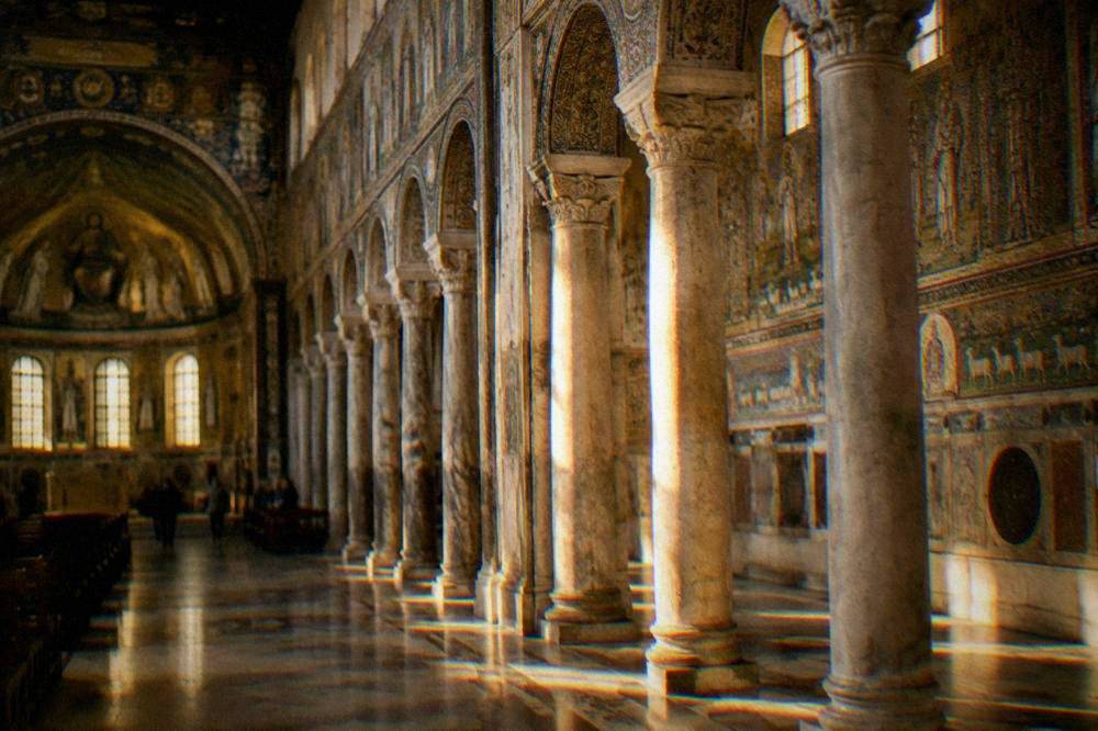Interior of a Ravenna basilica with rows of columns and mosaic decoration along the walls