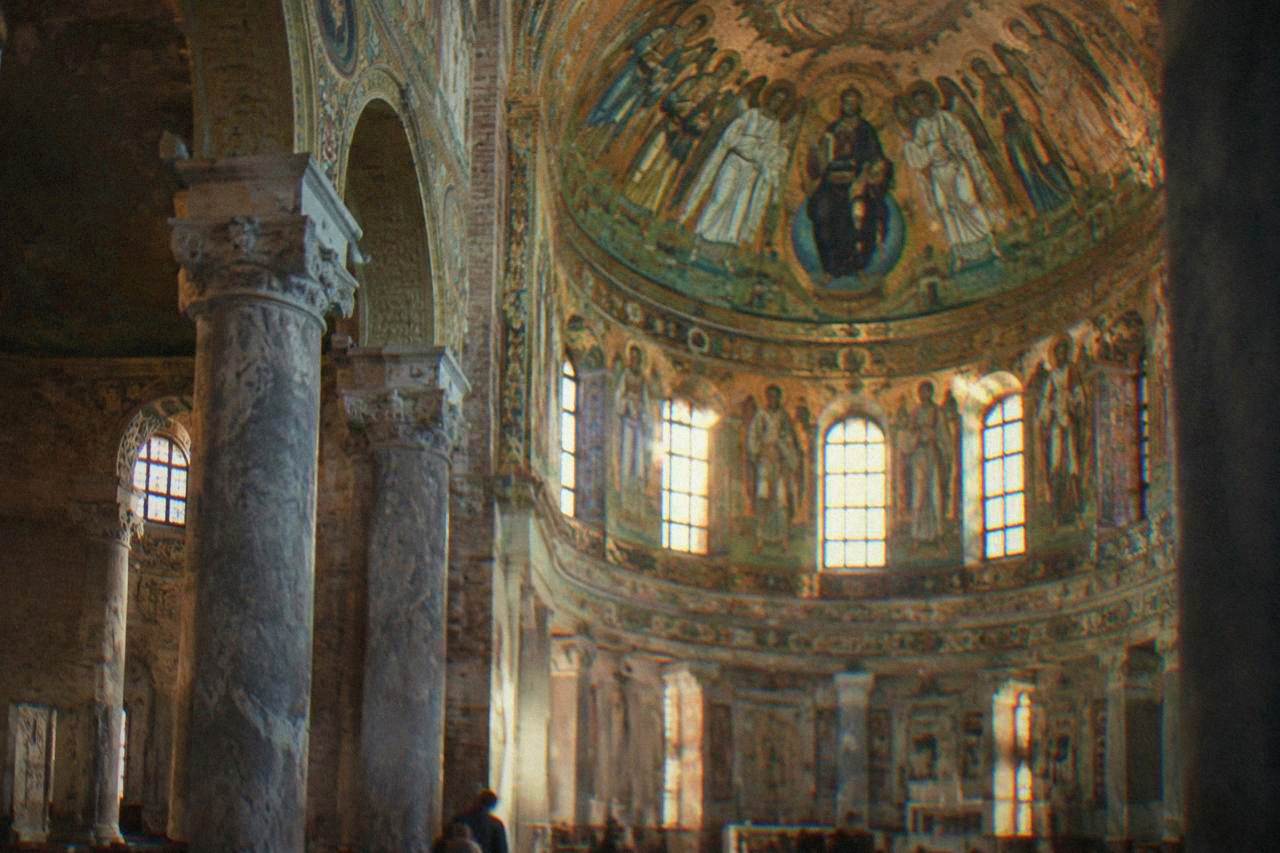 Golden mosaics glowing inside a domed Byzantine church interior in Ravenna