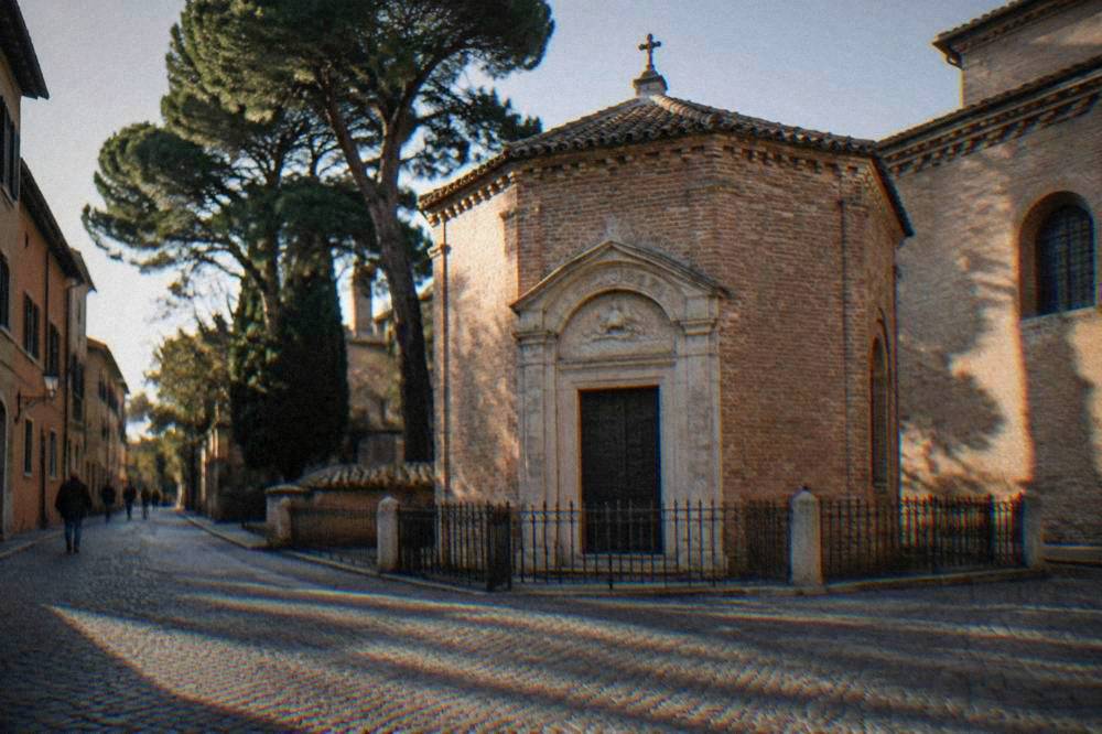 The small brick exterior of Dante's tomb in a quiet Ravenna street