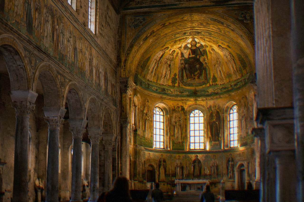 Golden Byzantine mosaics glowing inside the apse of a Ravenna basilica under soft interior light