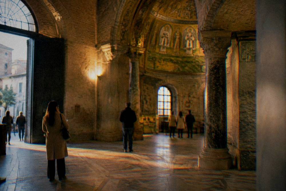 A ticket desk in a Ravenna monument with a queue of visitors holding printed entry times