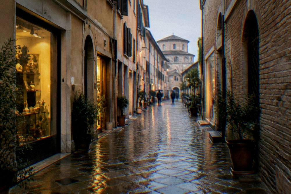 Rain-washed cobblestones in a narrow Italian old town lane reflecting warm shop lights